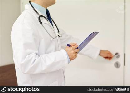 medicine, profession, healthcare and people concept - close up of doctor with clipboard and stethoscope at hospital opening door