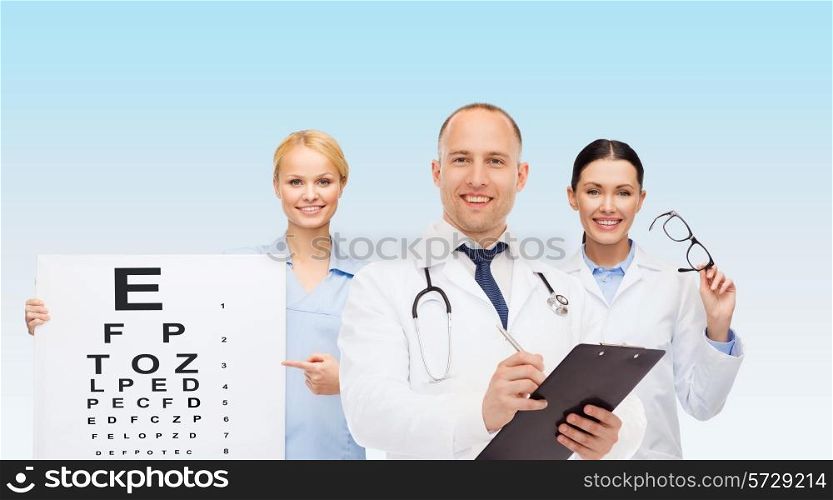 medicine, profession, teamwork and healthcare concept - international group of smiling medics or doctors with eye chart, clipboard and stethoscopes over blue background