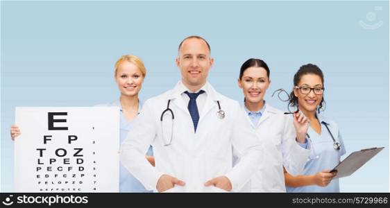 medicine, profession, teamwork and healthcare concept - international group of smiling medics or doctors with eye chart, clipboard and stethoscopes over blue background