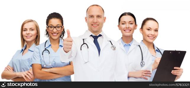 medicine, profession, teamwork and healthcare concept - international group of smiling medics or doctors with clipboard and stethoscopes with showing thumbs up over white background