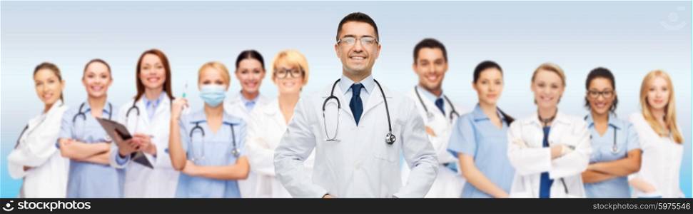 medicine, profession, teamwork and healthcare concept - international group of smiling medics or doctors with clipboard and stethoscopes over gray background