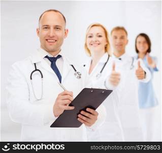 medicine, profession, teamwork and healthcare concept - smiling male doctor with clipboard and stethoscope writing prescription over white background