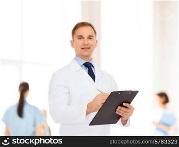medicine, profession, teamwork and healthcare concept - smiling male doctor with clipboard writing prescription over group of medics