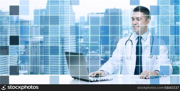 medicine, profession, technology and people concept - smiling male doctor sitting at table with laptop and stethoscope over city and blue grid background