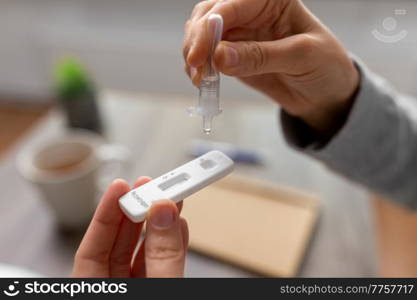 medicine, quarantine and pandemic concept - close up of woman making self testing coronavirus test at home. woman making self testing coronavirus test at home