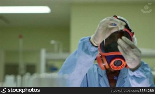 Medicine, science, and pharmaceutical laboratory with scientist wearing mask and looking at camera while working. Sequence