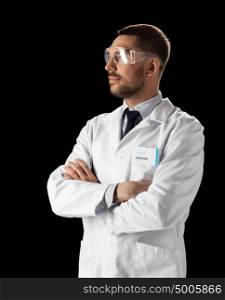 medicine, science, healthcare and people concept - male doctor or scientist in white coat and safety glasses over black background. doctor or scientist in lab coat and safety glasses