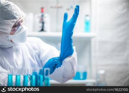 medicine specialist wearing PPE suit setting, medical people wearing surgical glove, face mask, and goggle to protection to work with coronavirus flu in hospital laboratory