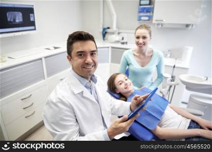 medicine, stomatology, technology and health care concept - happy male dentist with tablet pc computer, patient girl and her mother at dental clinic office