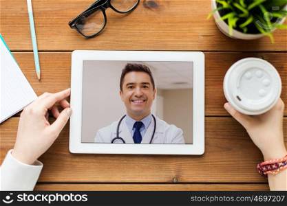 medicine, technology and healthcare concept - close up of woman or patient having video call with doctor on tablet pc computer at home. patient having video call with doctor on tablet pc