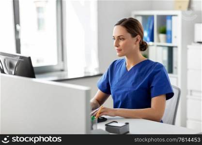medicine, technology and healthcare concept - female doctor or nurse with computer working at hospital. doctor or nurse with computer working at hospital