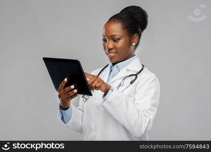 medicine, technology and healthcare concept - happy smiling african american female doctor or in white coat with tablet pc computer and stethoscope over background. african american female doctor with tablet pc