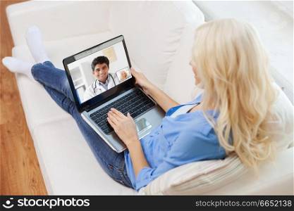 medicine, technology and healthcare concept - woman or patient having video call with male doctor on laptop computer at home. patient having video call with doctor on laptop