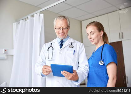 medicine, technology, health care and people concept - senior doctor and young nurse with tablet pc computer at hospital hospital ward