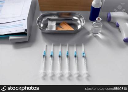 medicine, vaccination and healthcare concept - disposable syringes and other stuff on table at hospital. disposable syringes on table at hospital
