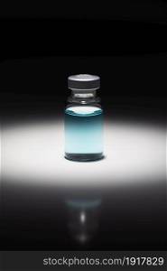 Medicine Vial With Light Blue Chemical Spot Lit on Reflective Background.