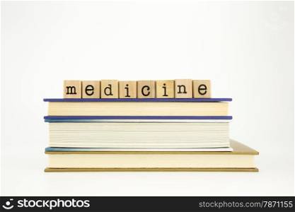 medicine word on wood stamps stack on books, academic and study concept