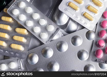 Medicines and pills in blisters are scattered on the table