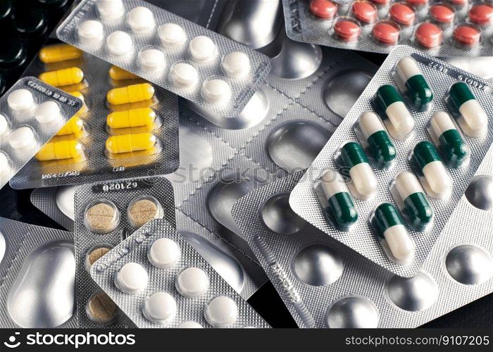 Medicines and pills in blisters are scattered on the table
