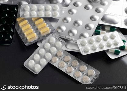 Medicines and pills in blisters are scattered on the table