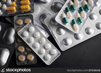 Medicines and pills in blisters are scattered on the table