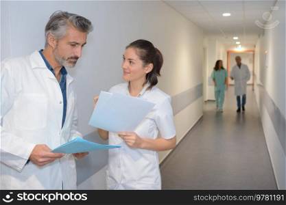 Medics conversing in hospital corridor