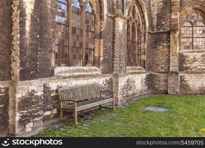Medieval abbey yard with wooden bench in Gent, Belgium&#xA;