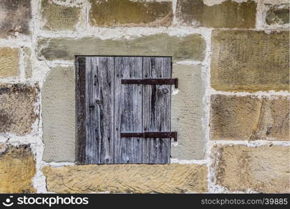 Medieval architecture background with a stone wall and a small wooden trap door