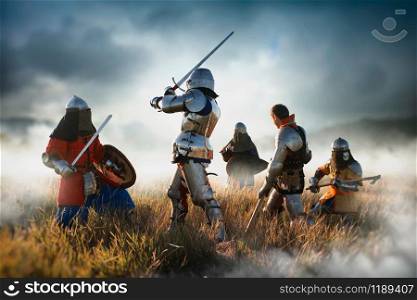 Medieval battle of knights in armor and helmets with swords and axes, great combat. Armored ancient warriors. Medieval knights fight, great combat