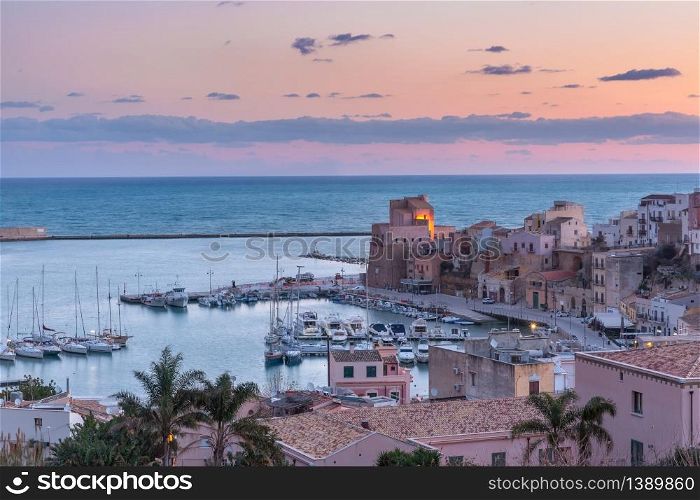 Medieval fortress in Cala Marina, harbor in coastal city Castellammare del Golfo at pink sunrise, Sicily, Italy. Castellammare del Golfo at sunrise, Sicily, Italy