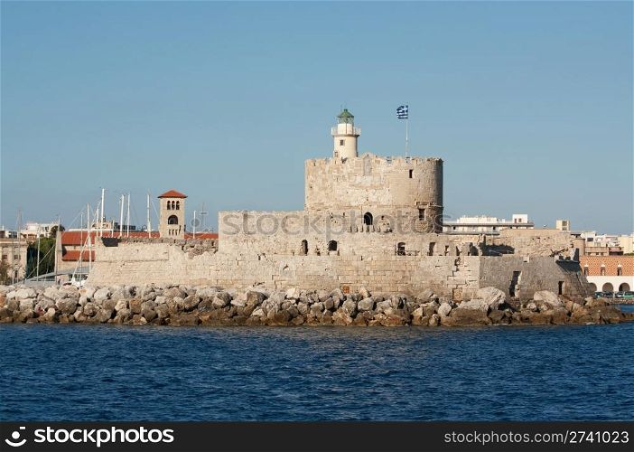 Medieval fortress of Saint Nicholas, now the site of a lighthouse, in Mandraki Harbour, Rhodes New Town, Greece.