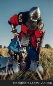 Medieval knight in armor and helmets put his sword to his opponent&rsquo;s throat, great tournament. Armored ancient warrior in armour posing in the field