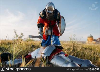 Medieval knight in armor and helmets put his sword to his opponent&rsquo;s throat. Armored ancient warrior in armour posing in the field. Knight put his sword to his opponent&rsquo;s throat