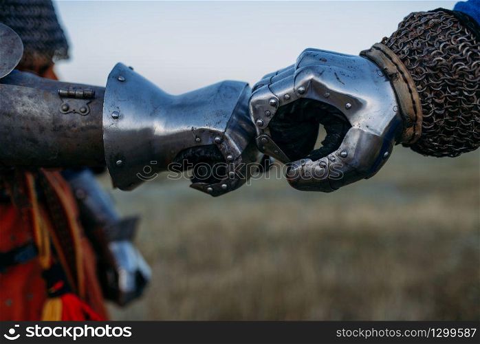 Medieval knights hands in metal gloves closeup view, great tournament. Armored ancient warrior in armour posing in the field