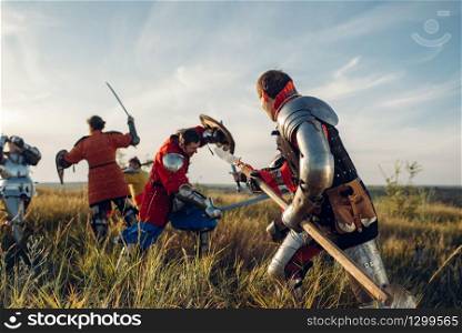 Medieval knights in armor standing opposite each other before battle. Armored ancient warrior in armour posing in the field. Medieval knights standing opposite each other