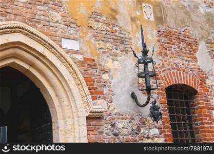 Medieval luminaire on old brick wall of a house