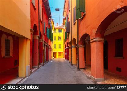Medieval street portico in Bologna, Italy. Medieval street portico with bright colored houses in the Old Town in the sunny day, Emilia-Romagna, Italy