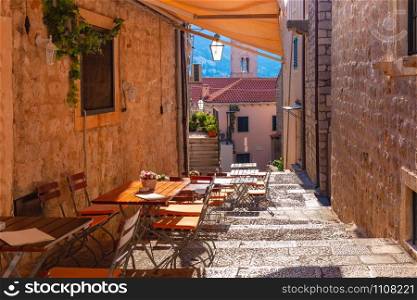 Medieval street with stairs and cafe tables in famous european city of Dubrovnik on a sunny day.. Old Town of Dubrovnik, Croatia