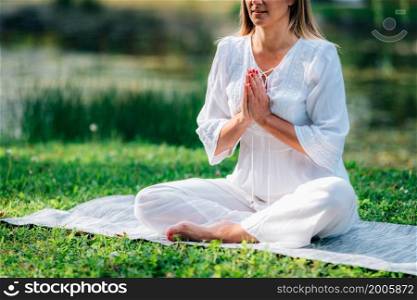 Meditation by the water, hands in prayer position, green background. . Meditation by the Water, Hands in Prayer Position.