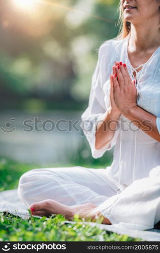 Meditation by the water, hands in prayer position, green background. . Meditation by the Water, Hands in Prayer Position.