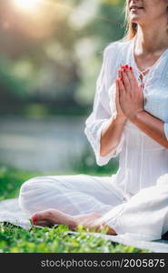 Meditation by the water, hands in prayer position, green background. . Meditation by the Water, Hands in Prayer Position.