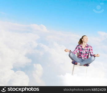 Meditation concept. Young woman sitting on chair and meditating