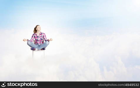 Meditation concept. Young woman sitting on chair and meditating