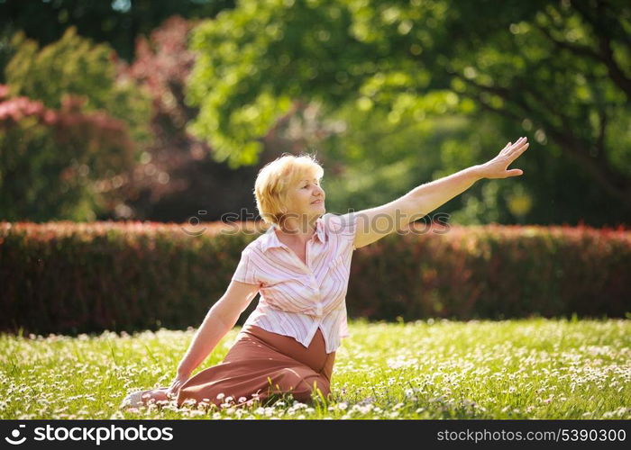 Meditation. Graceful Old Woman in the Park Stretching her Hand