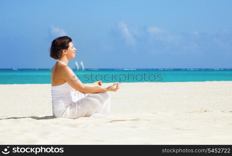 meditation of happy woman in lotus pose on the beach