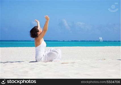 meditation of happy woman in lotus pose on the beach