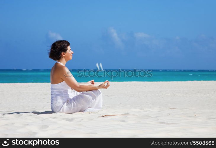 meditation of happy woman in lotus pose on the beach