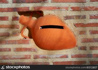 Mediterranan mailbox with clay jar of pottery. Mediterranan mailbox with clay jar of pottery in a brickwall