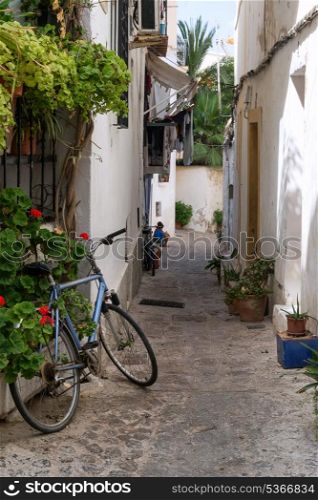 Mediterranean alley way between old houses and buildings with bike and local residents