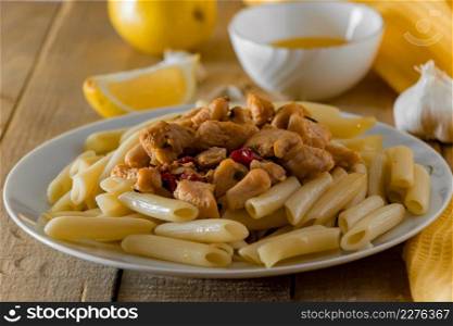 Mediterranean food - penne pasta and delicious chicken in a creamy sauce on a yellow napkin.. Mediterranean food - penne pasta and chicken in a creamy sauce on a yellow napkin.